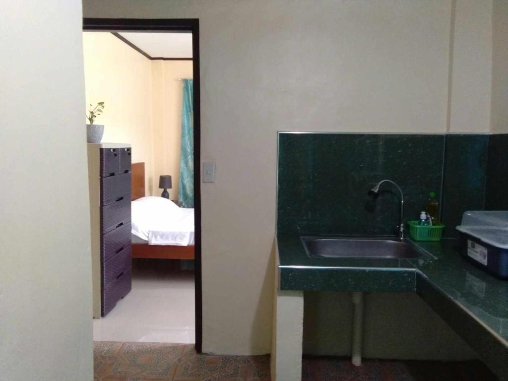 a bathroom with a sink and a bedroom with a bed at Casa Esmeralda in Lupao