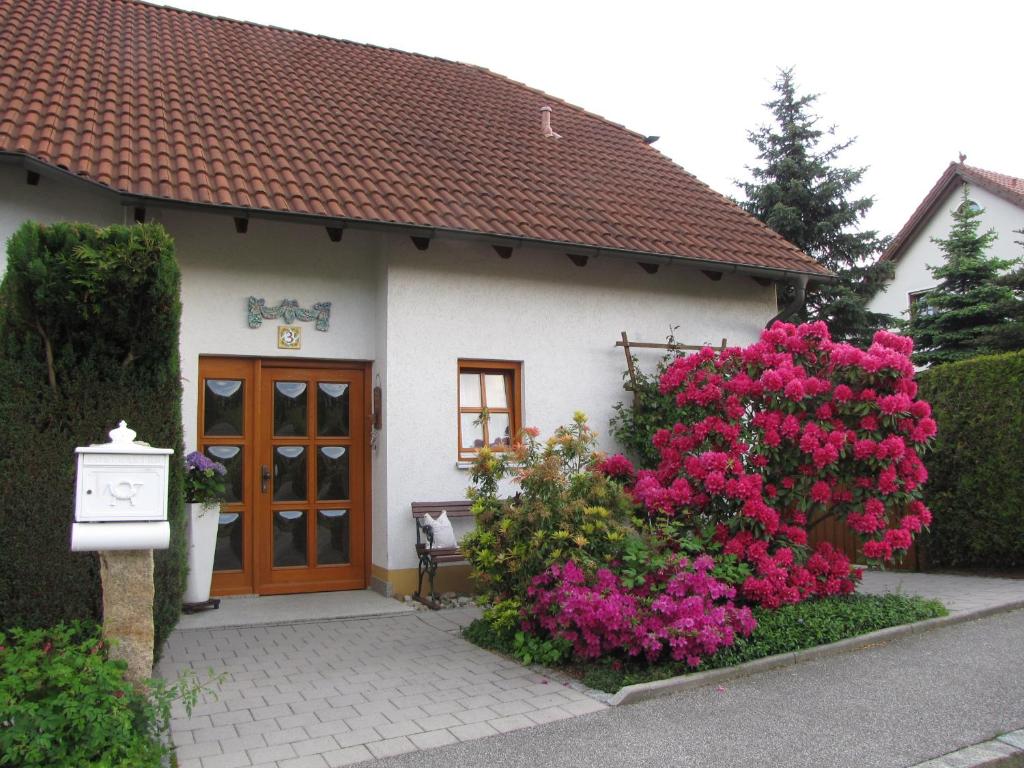 una pequeña casa con flores rosas delante en LandLiebe, en Tännesberg
