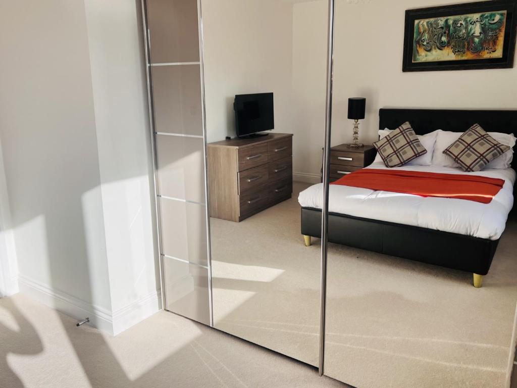 a bedroom with a bed and a mirror at Elegant Double Room with Ensuite in Central Reading in Reading