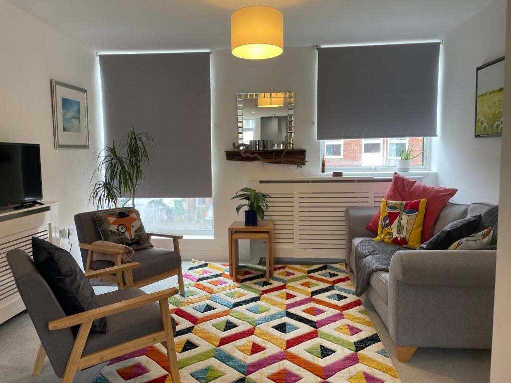 a living room with a couch and chairs on a rug at Modern and Comfortable Flat with private parking in Oxford