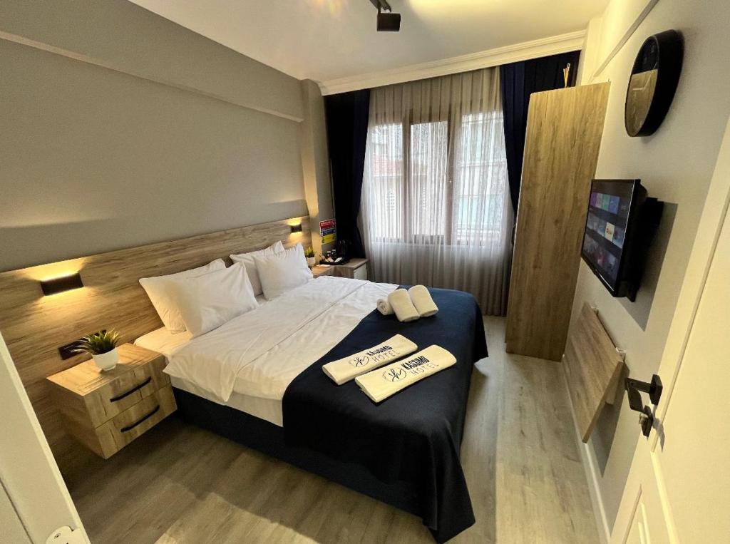 1 dormitorio con 1 cama y 2 toallas en una mesa en Kassimo Hotel en Estambul
