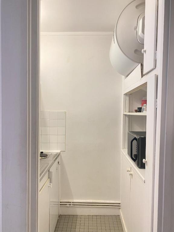 a small kitchen with white cabinets and a microwave at Super appartement 3T proche Tour Eiffel in Paris