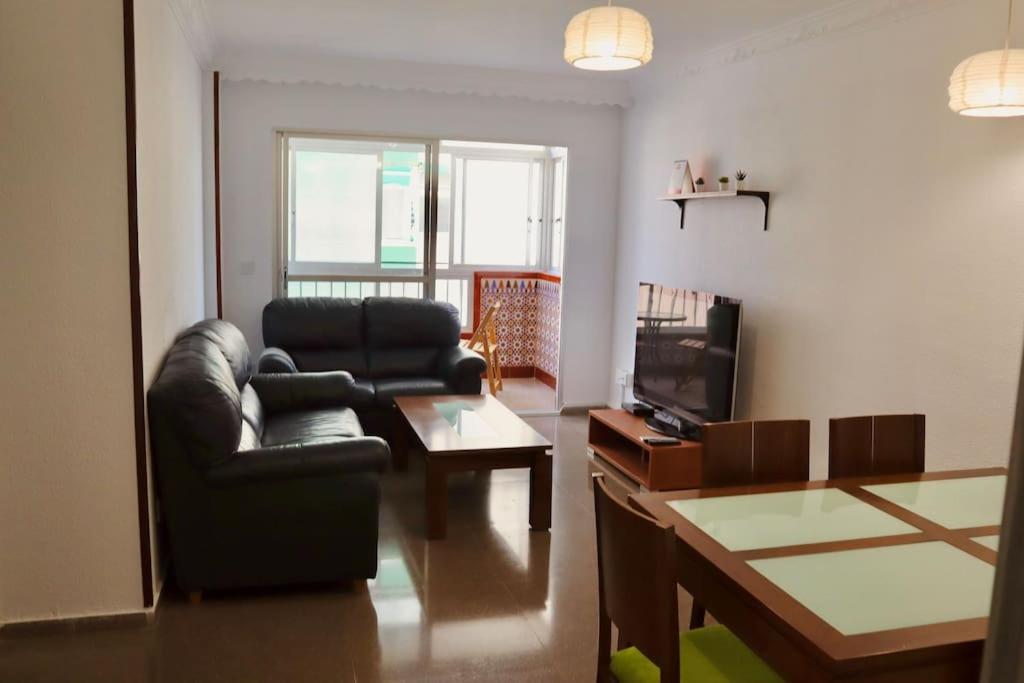 - un salon avec un canapé en cuir et une télévision dans l'établissement Apartamento en Málaga, Vialia, à Malaga
