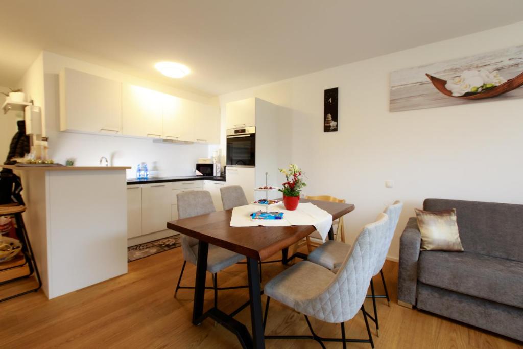 eine Küche und ein Wohnzimmer mit einem Tisch und Stühlen in der Unterkunft Wohlfühlapartment 24 in Götzis