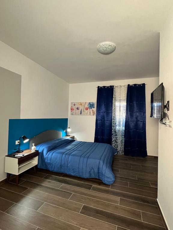 a bedroom with a blue bed and a desk at B&B ILSE in Capua