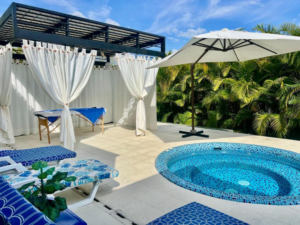een patio met een zwembad en een parasol bij Luxury Mocawa House: Two Jacuzzis, Pool & BBQ. in La Tebaida