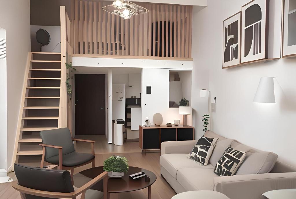 uma sala de estar com um sofá, uma mesa e uma escada em Tinyhouse Experience in Beaujolais em Villefranche-sur-Saône