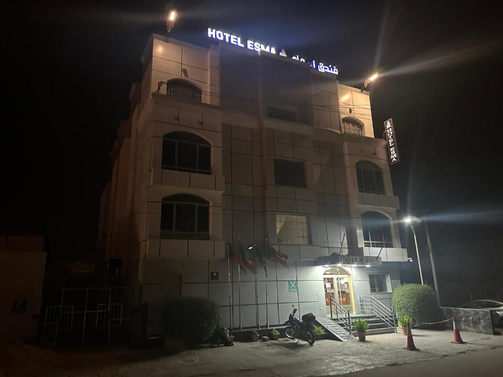 a building with a sign on top of it at night at Hôtel Esma Nouadhibou in Nouadhibou