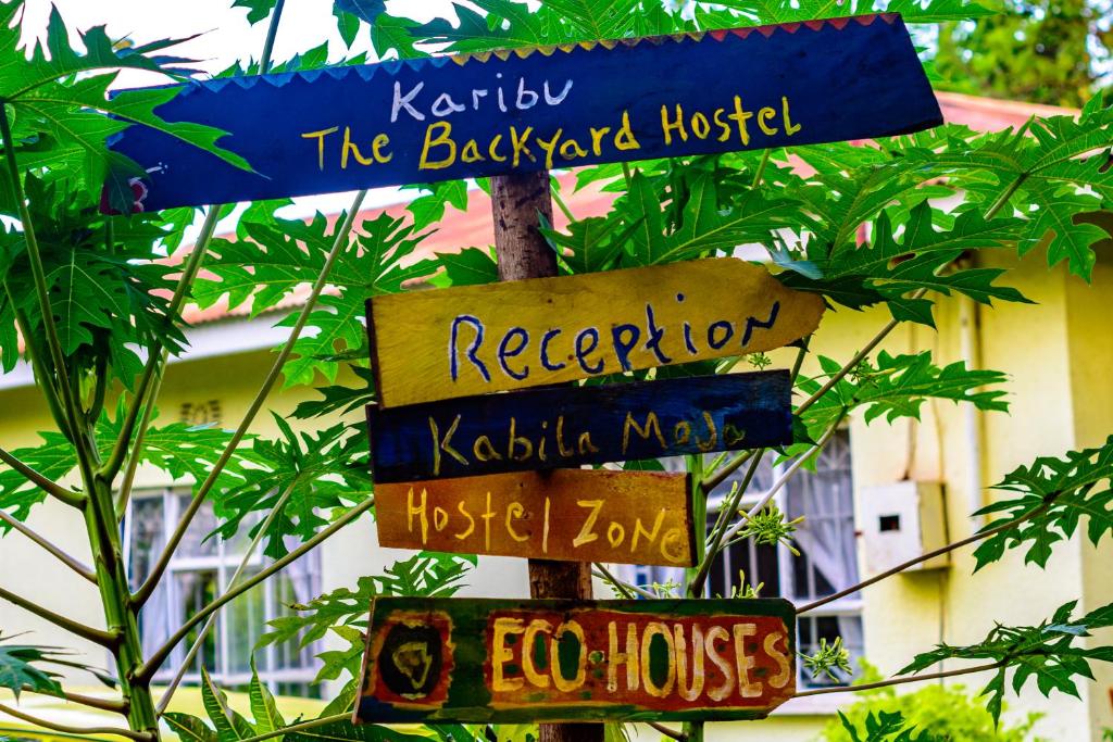 znak drogowy z kilkoma znakami na słupie w obiekcie Backyard Hostel w mieście Moshi