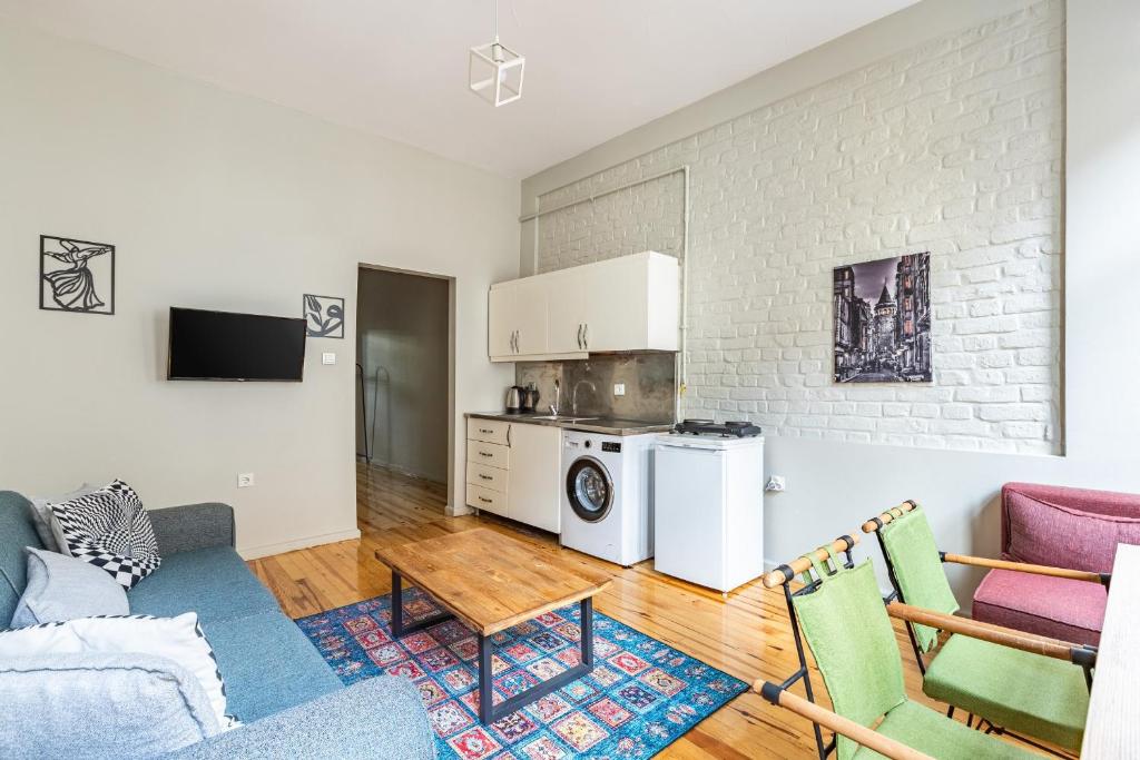 een woonkamer met een bank, een tafel en een keuken bij Pin Exclusive 1 BD Taksim A3 in Istanbul