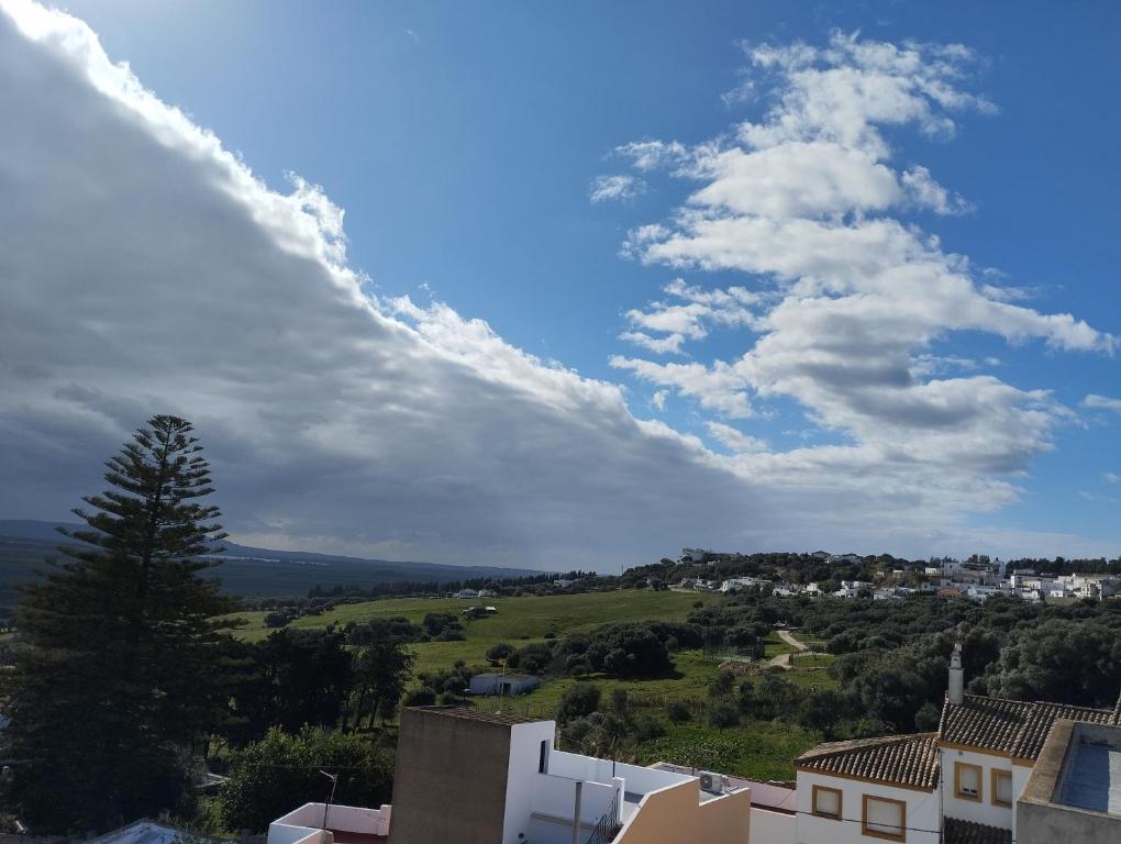 un cielo nublado sobre un campo verde y casas en El Celemín, en Benalup-Casas Viejas