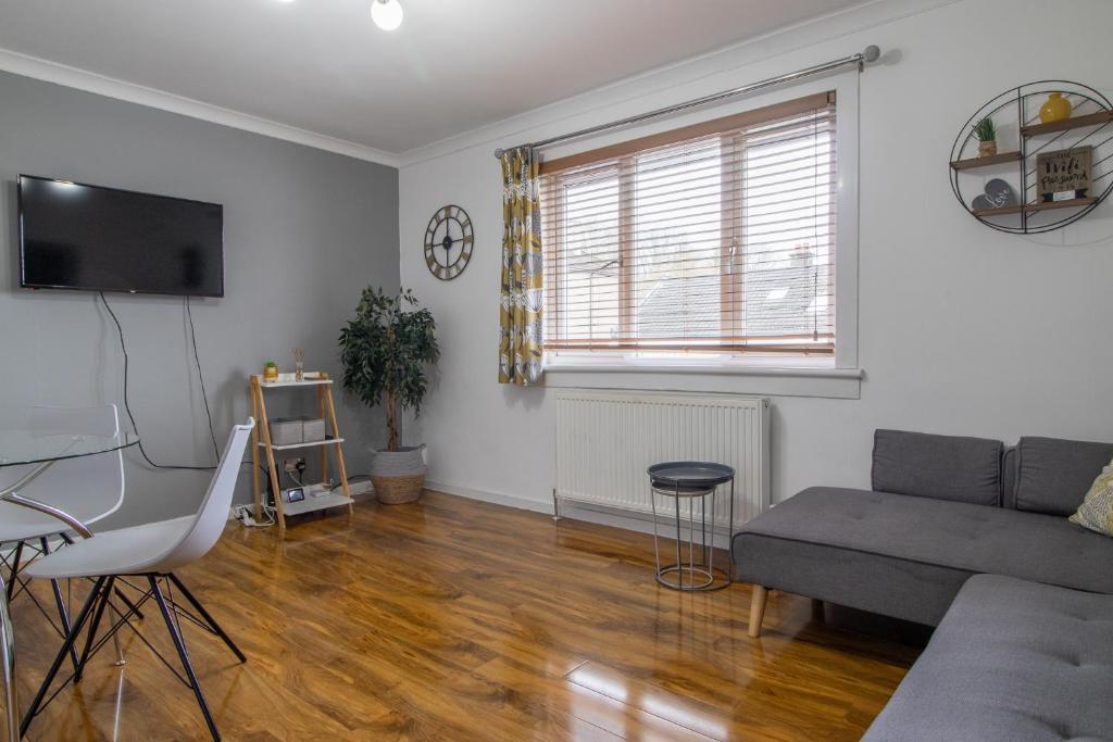 uma sala de estar com um sofá e uma mesa em 1 bed apartment central Hamilton free wifi with great transport links to Glasgow em Hamilton