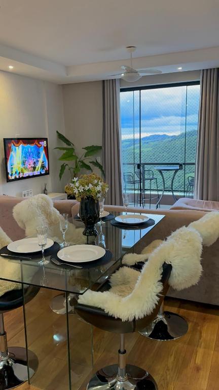 a living room with a couch and a glass table at A Melhor vista de água de Lindóia in Águas de Lindóia