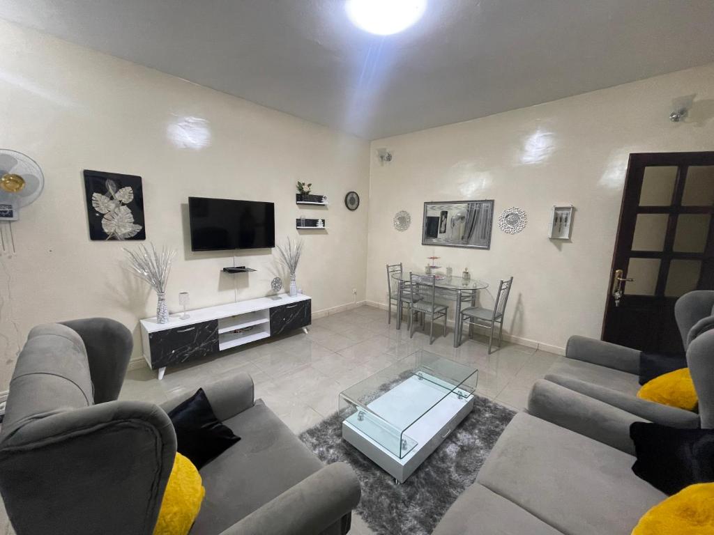 a living room with couches and a tv and a table at Luxe et confort a ngor dans un quartier très accessible in Ngor