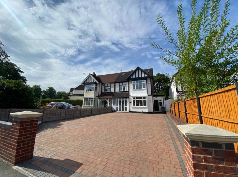 a large white house with a brick driveway at The Woodstock in Birmingham