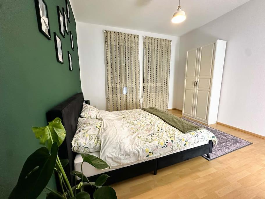 a bedroom with a bed and a plant in it at Gemütliche 2-Zimmer Wohnung im Zentrum in Neumünster