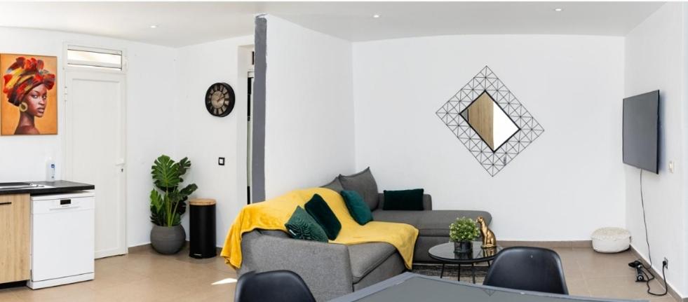 uma sala de estar com um sofá e uma mesa em Villa orchidée em Les Abymes