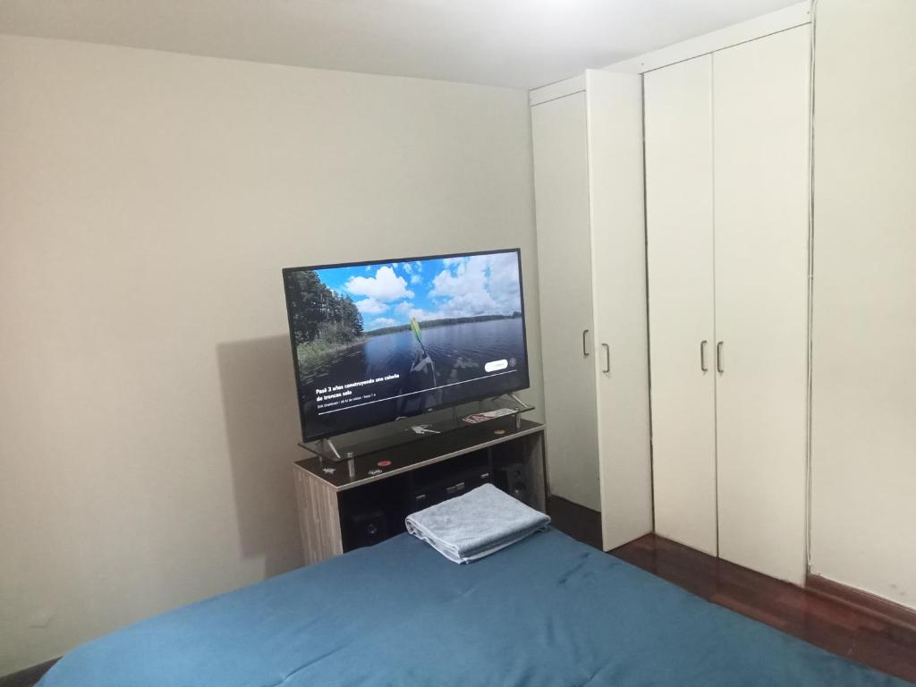 een slaapkamer met een flatscreen-tv en een bed bij Acogedora Habitacion Independiente in Lima