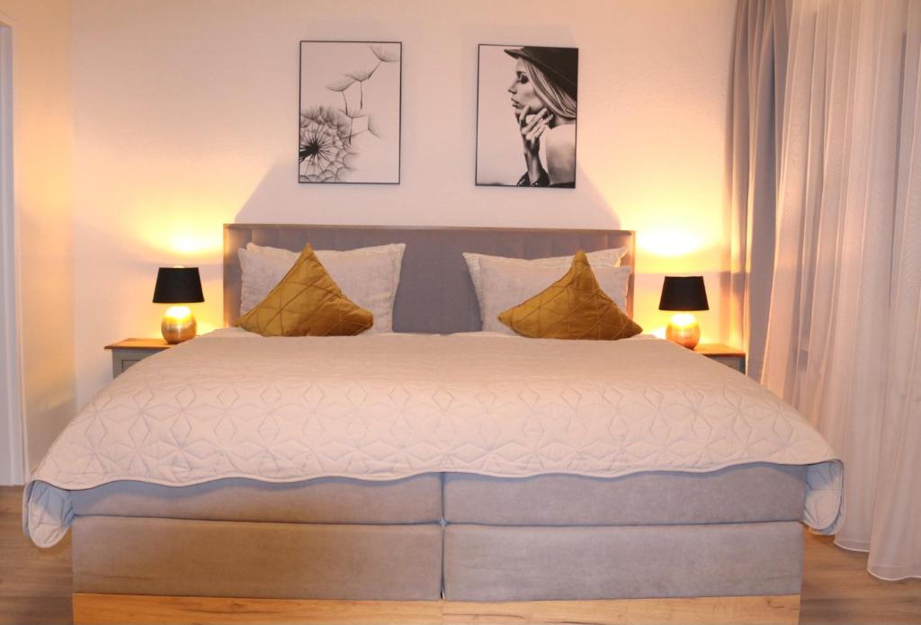 a bedroom with a large bed with two lamps at PANORAMA INN - nahe Messe contaktless check-in in Hannover