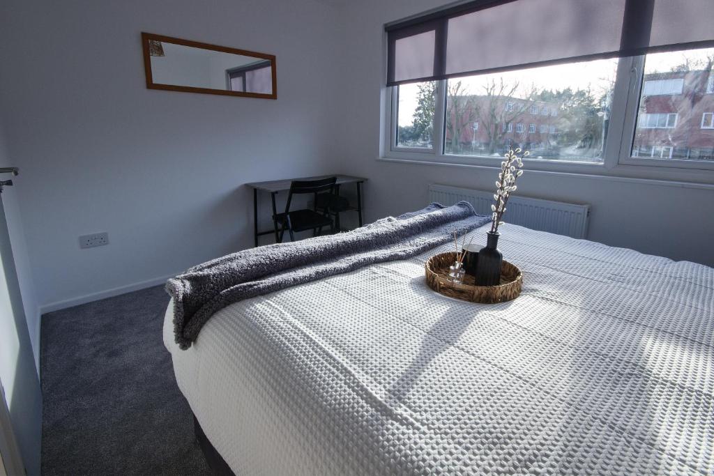 een slaapkamer met een wit bed met een deken erop bij Contractors, Medical staff, Relocators, Families- 5 Bedroom 3 bathroom house- 2min walk to L&D in Luton