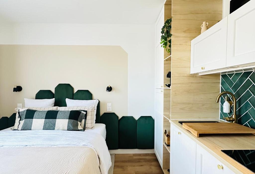 - une chambre avec un lit doté d'une tête de lit verte dans l'établissement L’émeraude - Superbe studio tout équipé + parking, à Metz