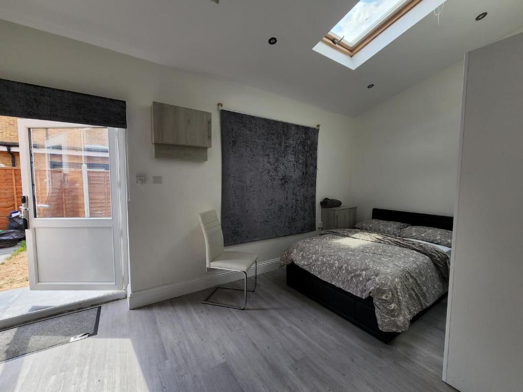 1 dormitorio con 1 cama y 1 silla en Ilford Town Centre Studio, en Ilford