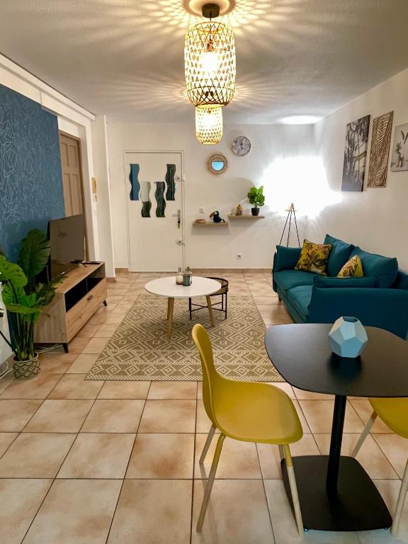 a living room with a blue couch and yellow chairs at Le Toucan Tropical, F2 bis emplacement central in Fort-de-France