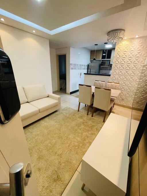 ein Wohnzimmer mit einem Sofa und einem Tisch in der Unterkunft Apto VIP em frente à ARENA MRV / Expominas in Belo Horizonte