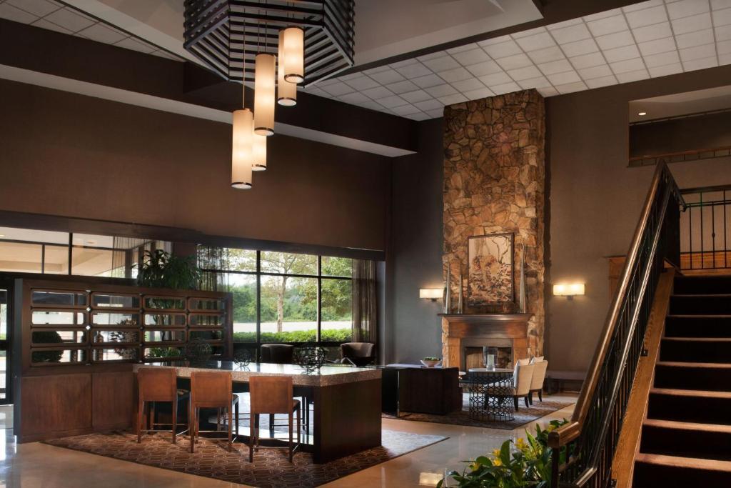 a lobby with a table and chairs and a staircase at Sheraton Bucks County Langhorne in Langhorne