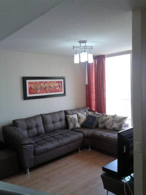 a living room with a couch and a window at Tait's House - Cómodo departamento Dúplex - Ate in Lima
