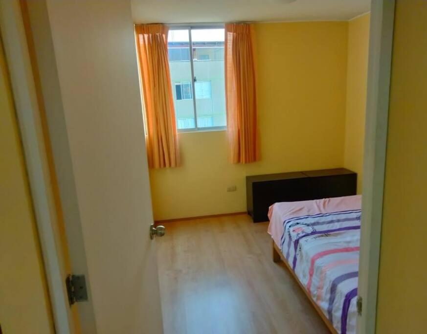 um quarto com uma cama e uma janela em Tait's House - Cómodo departamento Dúplex - Ate em Lima
