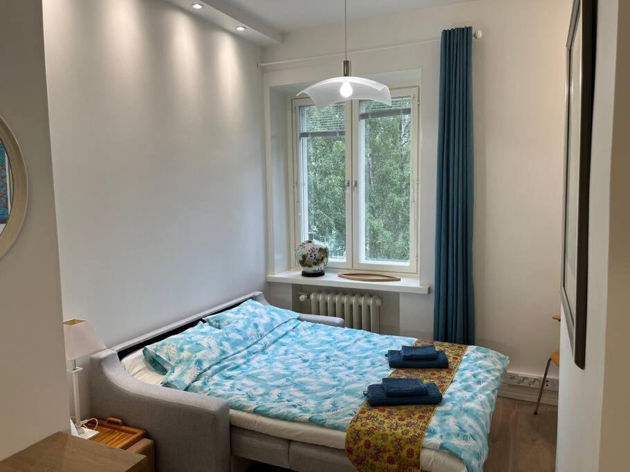 um quarto com uma cama e uma janela em Cozy apartment next to Finnish culture spots em Helsinque