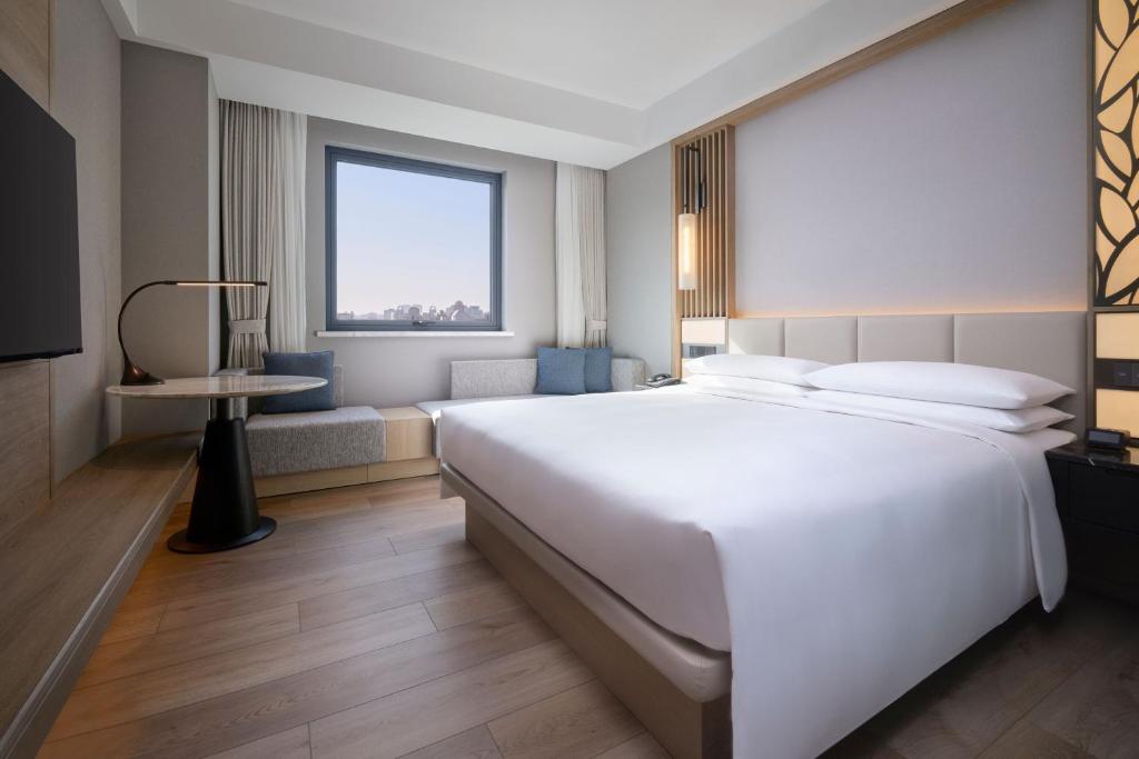 Postel nebo postele na pokoji v ubytování Courtyard By Marriott Shanghai Xujiahui