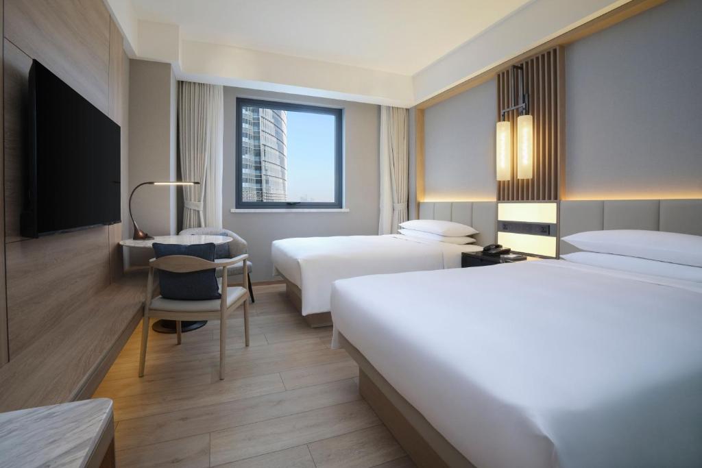 Postel nebo postele na pokoji v ubytování Courtyard By Marriott Shanghai Xujiahui