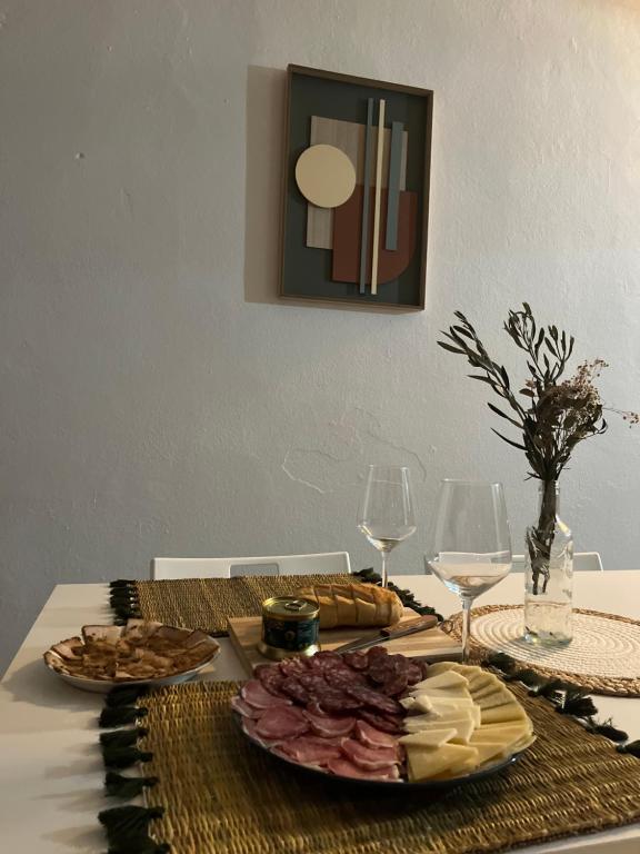 a table with a plate of food and wine glasses at Casa Almonte in Almonte