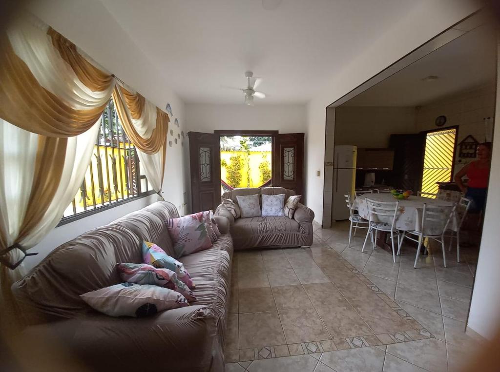 un salon avec un canapé et une salle à manger avec une table dans l'établissement Recanto da praia, à Bertioga