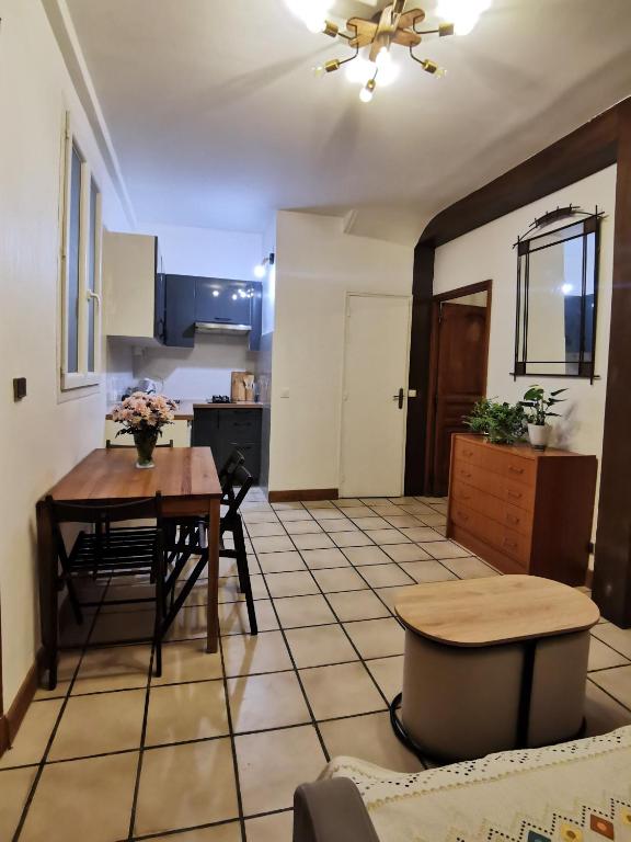 un salon avec une table et une cuisine dans l'établissement L'Cosy Suite - Charming 2BR in Bagnolet, à Bagnolet