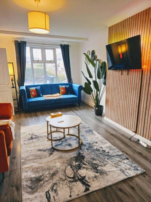 een woonkamer met een blauwe bank en een tafel bij SwankyHome4Groups/Contractors/M6 in Birmingham