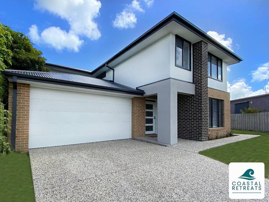 a detached house with a white garage at Scotty’s Place – Luxury Retreat in Inverloch