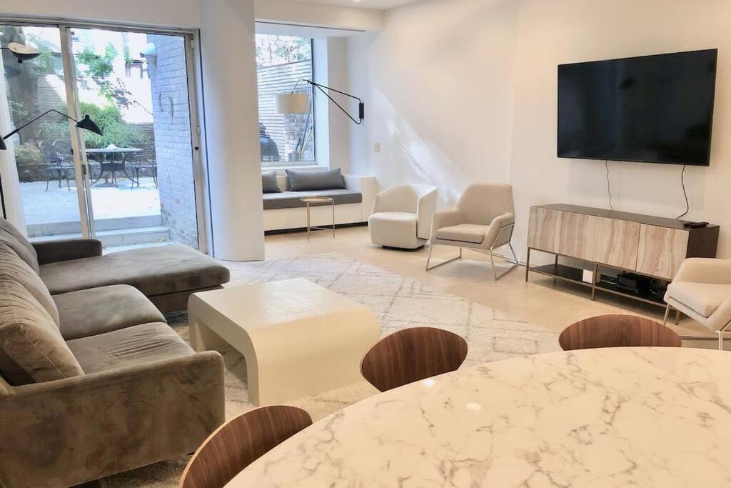 a living room with a couch and a tv at Private Beautiful Eastside Townhome near UN in New York