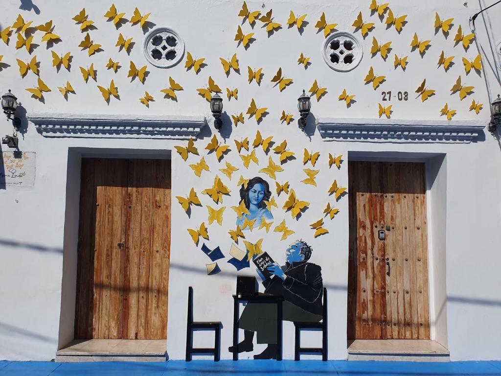 a painting of a man sitting in front of a wall with yellow stars at Casa Evelyn in Cartagena de Indias
