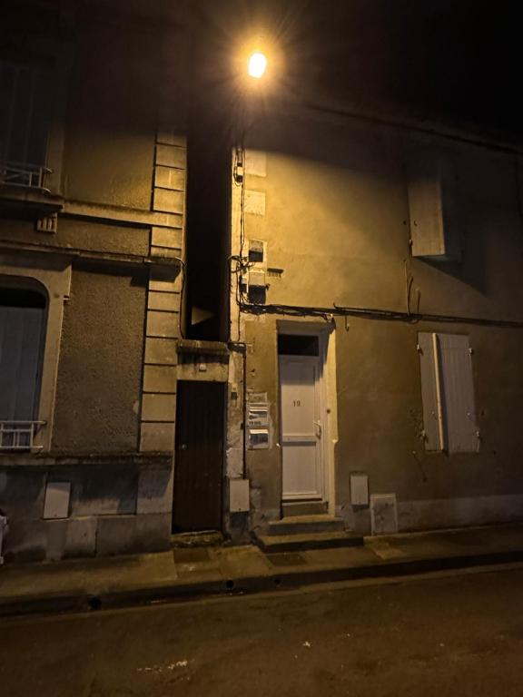 a street light on the side of a building at night at Location saisonnière Angoulême in Angoulême