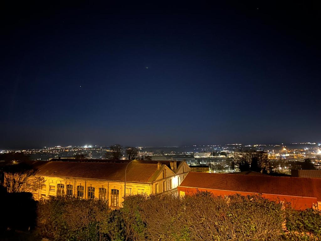 a building at night with a city in the background at Location saisonnière Angoulême in Angoulême