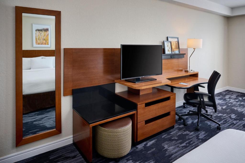 a hotel room with a desk with a television and a bed at Fairfield Inn & Suites by Marriott Ottawa Kanata in Ottawa