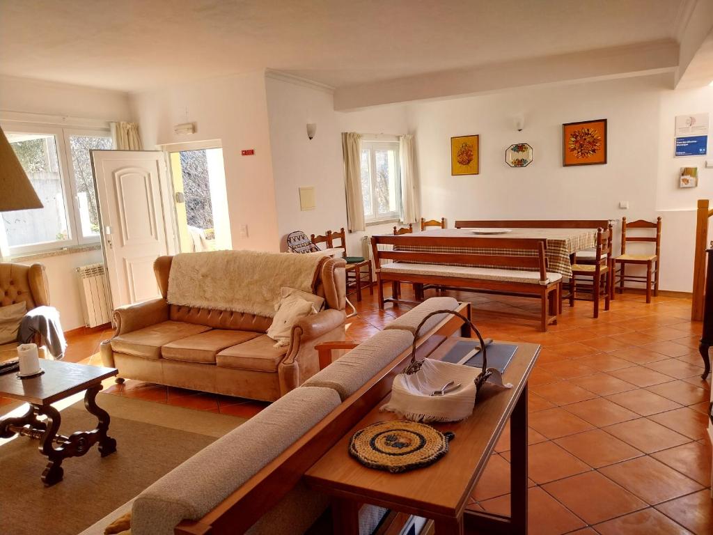 sala de estar con sofá y piano en Casa das Oliveiras - Manteigas, en Manteigas