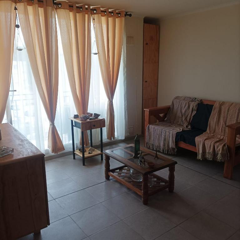 a living room with a couch and a table at Amplio y comodo departamento in La Serena