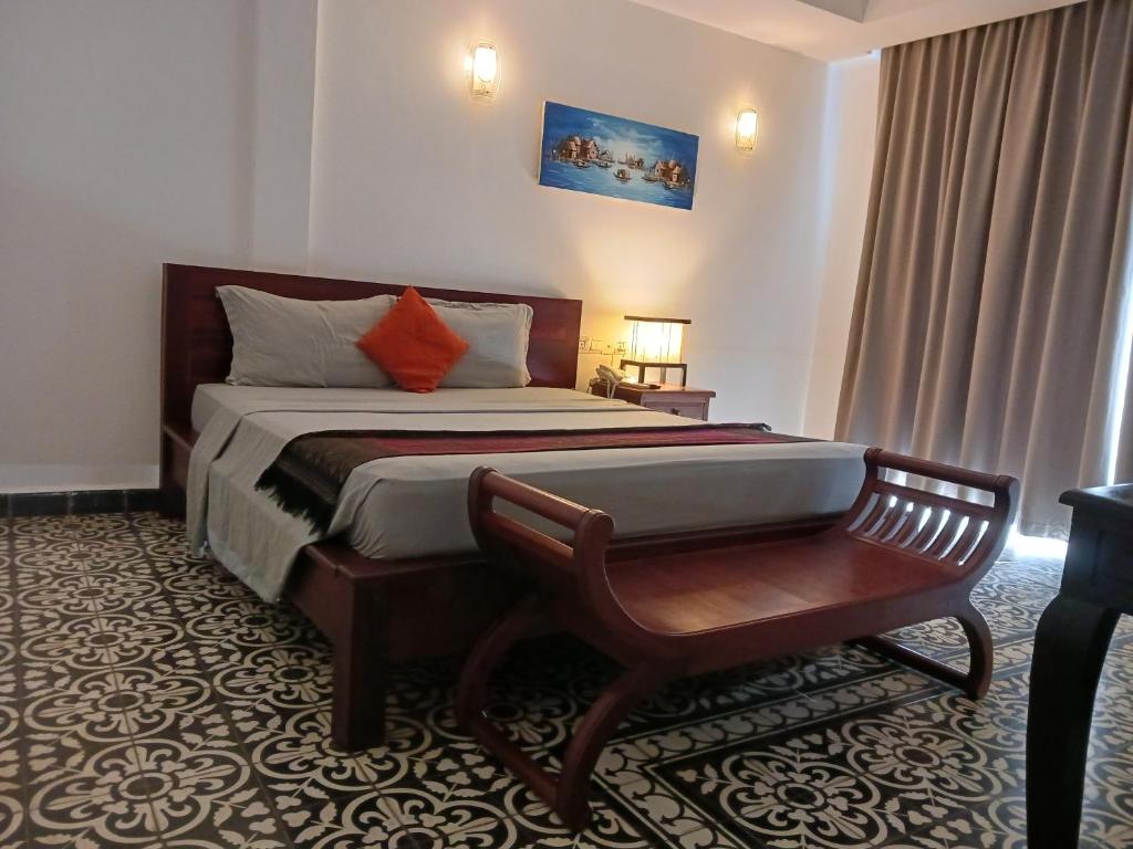 a bedroom with a bed and a bench in it at Andy's Place in Siem Reap