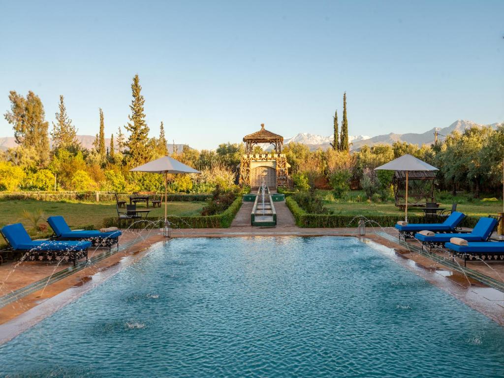 a swimming pool with chairs and a gazebo at Castle d'Atlas Riad & Spa in Marrakesh
