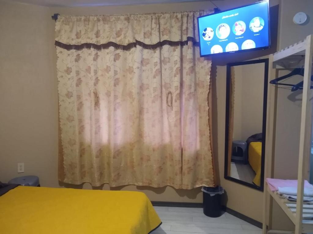 a room with a window with a television in it at Posada Lindavista in Tulancingo