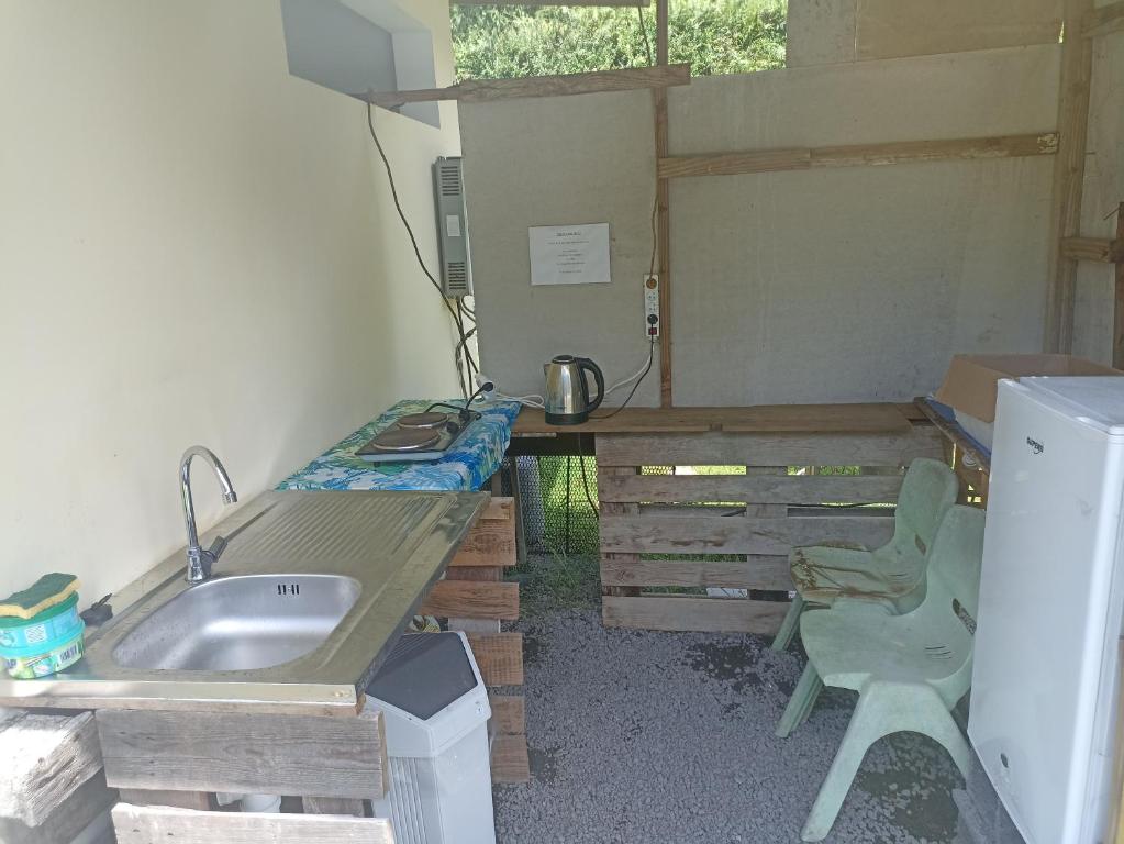 a small kitchen with a sink and a desk at Camping TENUI in Taputapuapea